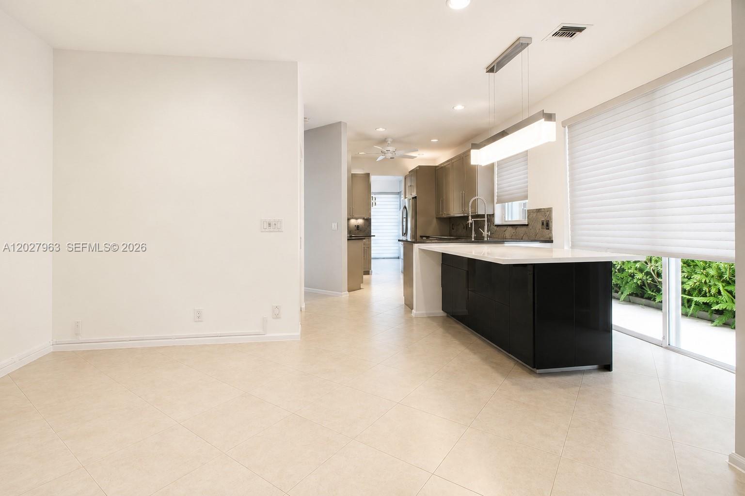 6646 Northwest 25th Terrace Boca Raton, FL 33496 - Photo 11 of 48 a view of a kitchen with kitchen island a sink wooden floor and a counter top space