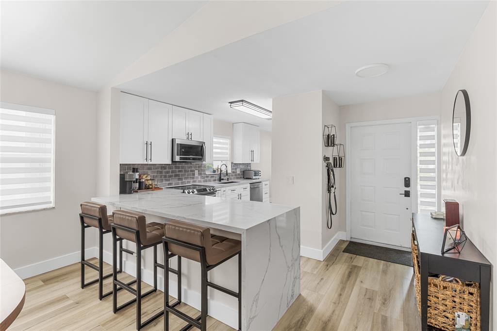 9424 Northwest 8th Circle Plantation, FL 33324 - Photo 3 of 57 a kitchen with stainless steel appliances a white table chairs and a refrigerator