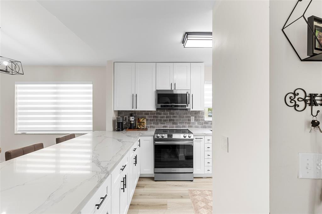 9424 Northwest 8th Circle Plantation, FL 33324 - Photo 6 of 57 a kitchen with stainless steel appliances granite countertop a stove top oven a sink and a refrigerator