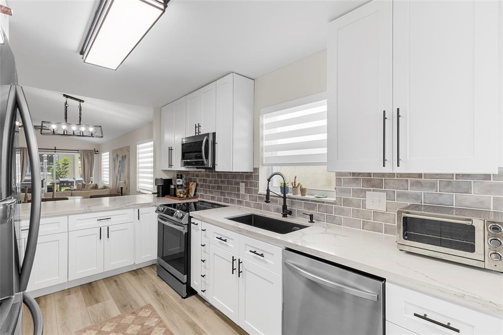9424 Northwest 8th Circle Plantation, FL 33324 - Photo 7 of 57 a kitchen with granite countertop a sink stainless steel appliances and cabinets