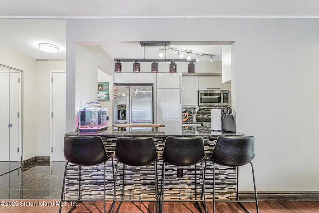 a kitchen with stainless steel appliances kitchen island granite countertop a dining table and chairs