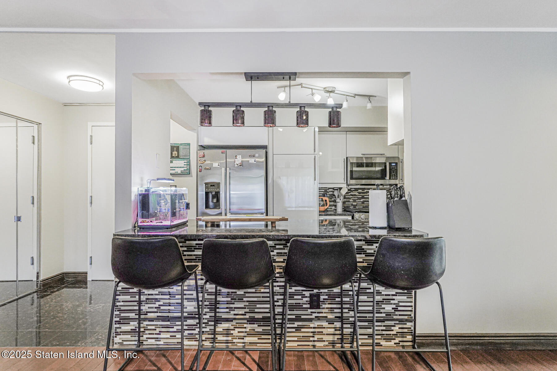 40 Wellington Court, Unit 2A Staten Island, NY 10314 - Photo 8 of 20 a kitchen with stainless steel appliances kitchen island granite countertop a dining table and chairs