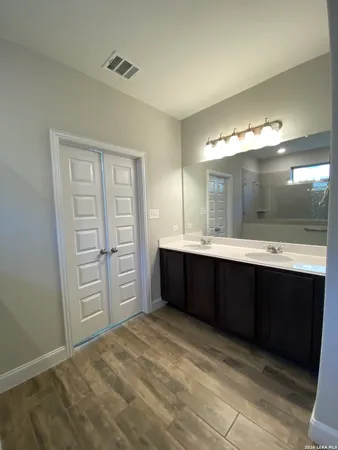 a bathroom with a bathtub sink double vanity and a mirror