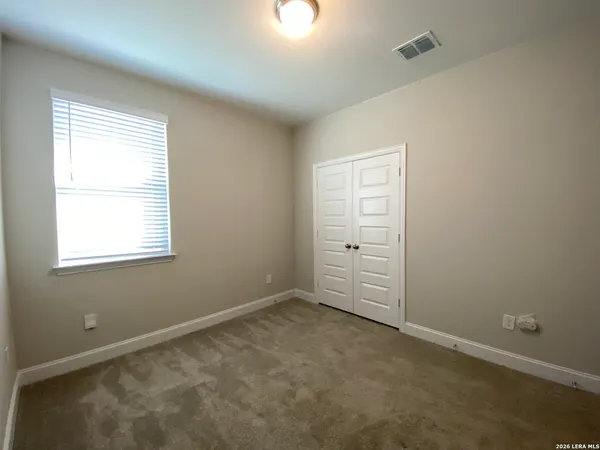 an empty room with windows and closet