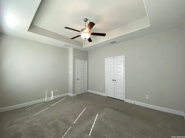 an empty room with a ceiling fan and a window