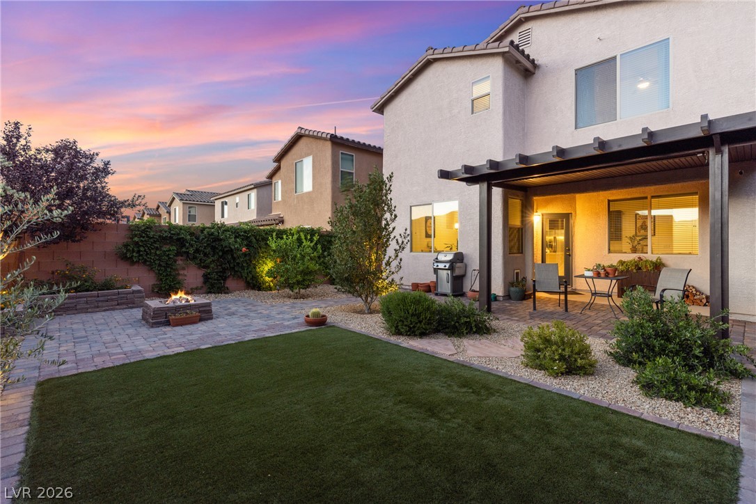 891 Earth Luster Road Las Vegas, NV 89178 - Photo 38 of 48 A private backyard oasis with fire pit, paved patio, and pergola-covered dining area.