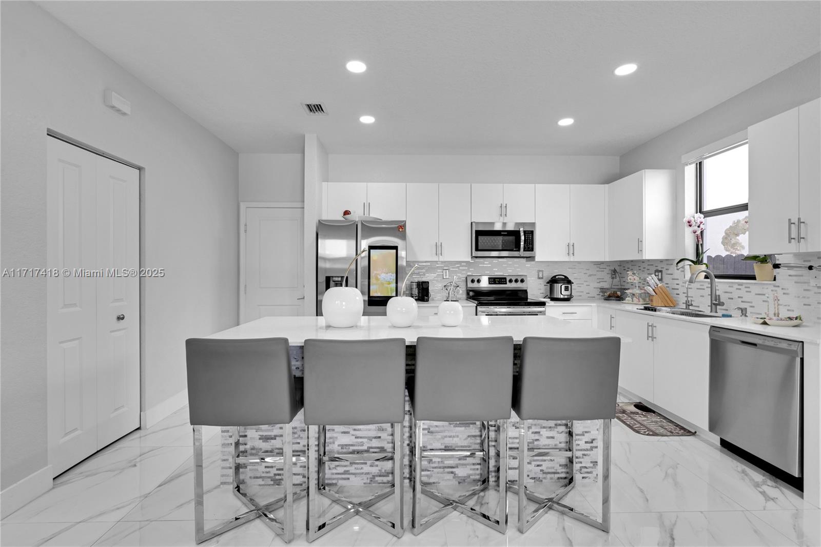 12953 Southwest 230th Street Miami, FL 33170 - Photo 12 of 49 a kitchen with stainless steel appliances granite countertop a stove a sink a refrigerator a microwave and white cabinets
