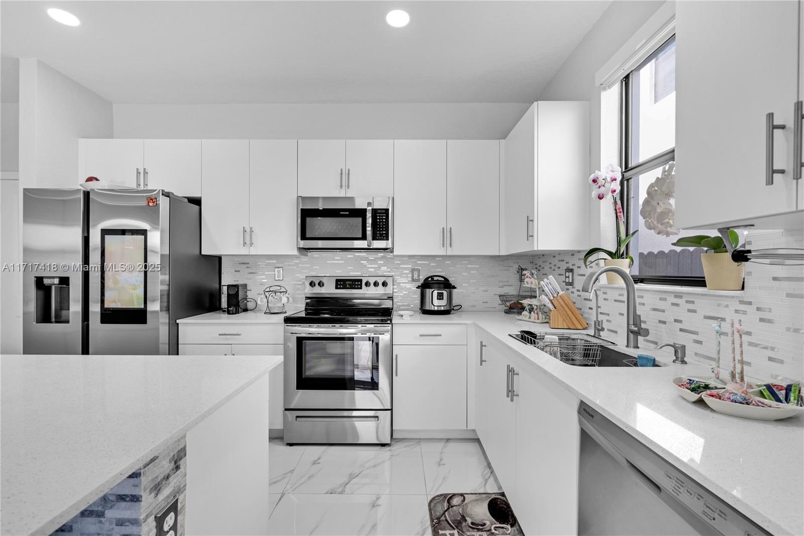 12953 Southwest 230th Street Miami, FL 33170 - Photo 14 of 49 a kitchen with a sink stove and refrigerator