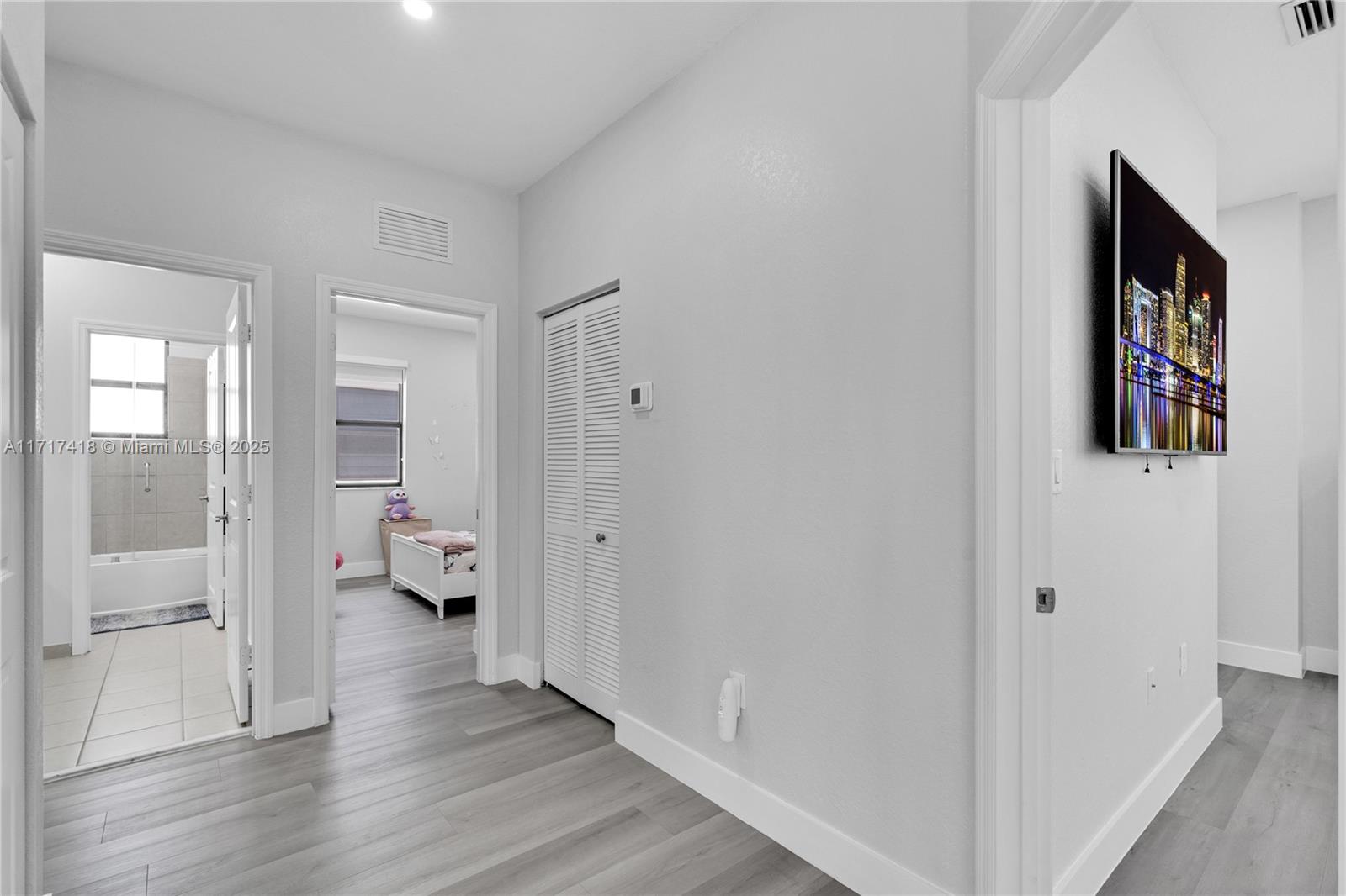 12953 Southwest 230th Street Miami, FL 33170 - Photo 36 of 49 a hallway with wooden floor windows and a bedroom