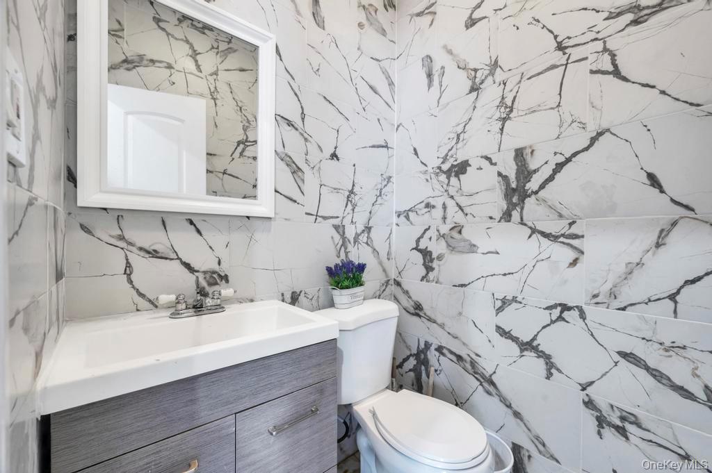 178-26 Zoller Road Queens, NY 11434 - Photo 15 of 26 a bathroom with a sink vanity mirror and toilet