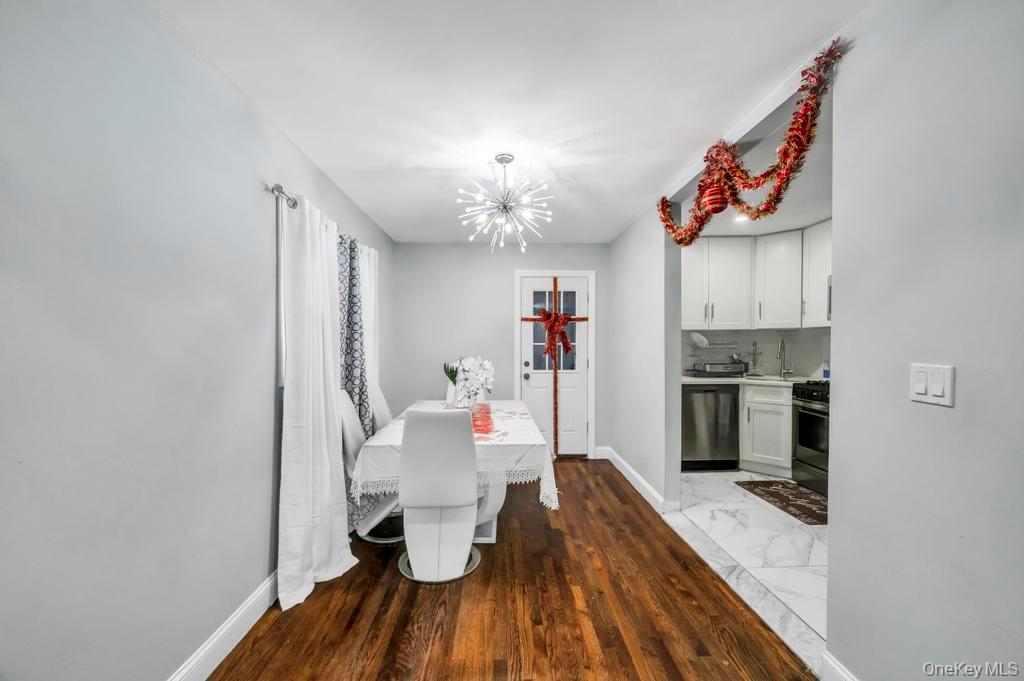 178-26 Zoller Road Queens, NY 11434 - Photo 10 of 26 a dining room with wooden floor a chandelier and entryway
