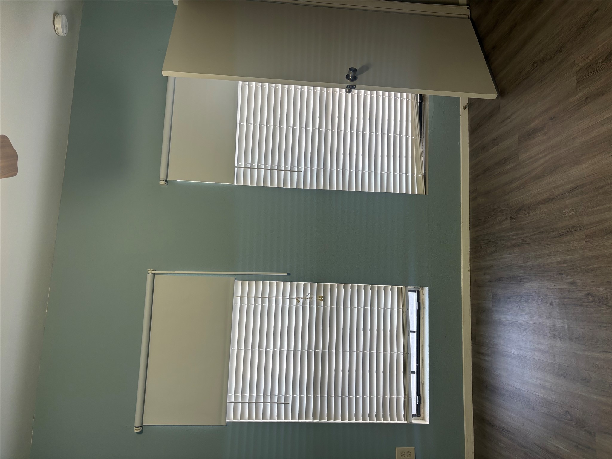 2801 Rio Grande Street, Unit 208 Austin, TX 78705 - Photo 6 of 8 Well-lit room featuring durable wood-like flooring and multiple window treatments.