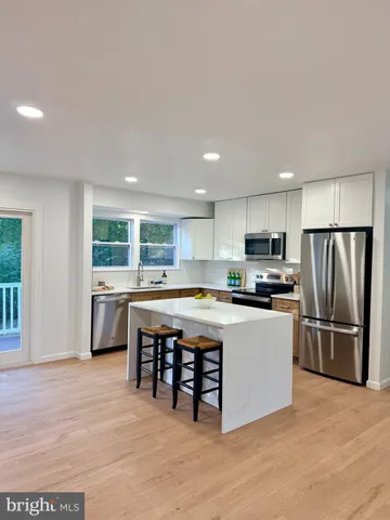 a kitchen with stainless steel appliances a refrigerator a sink dishwasher with a stove and cabinets