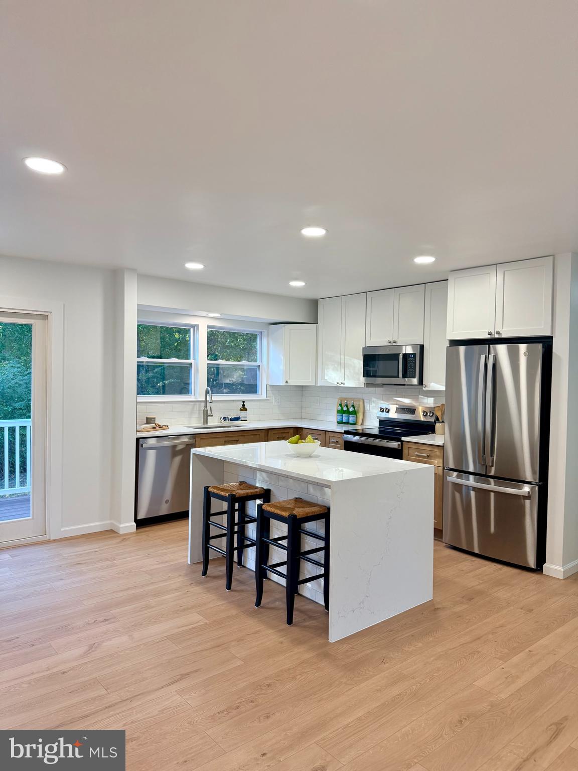 a kitchen with stainless steel appliances a refrigerator a sink dishwasher with a stove and cabinets