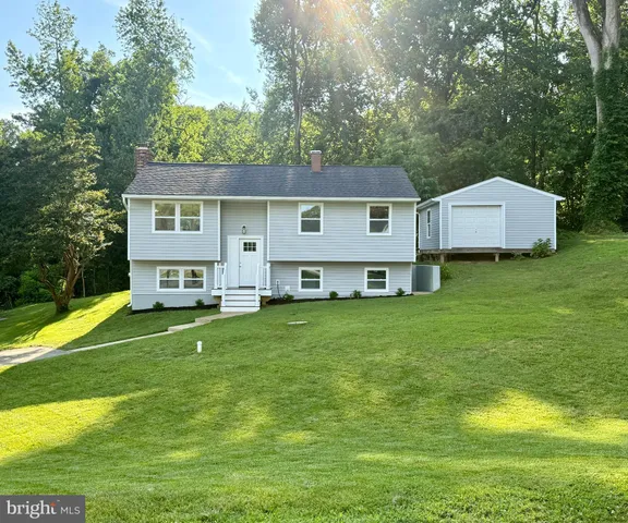 a view of a house with a big yard and large trees