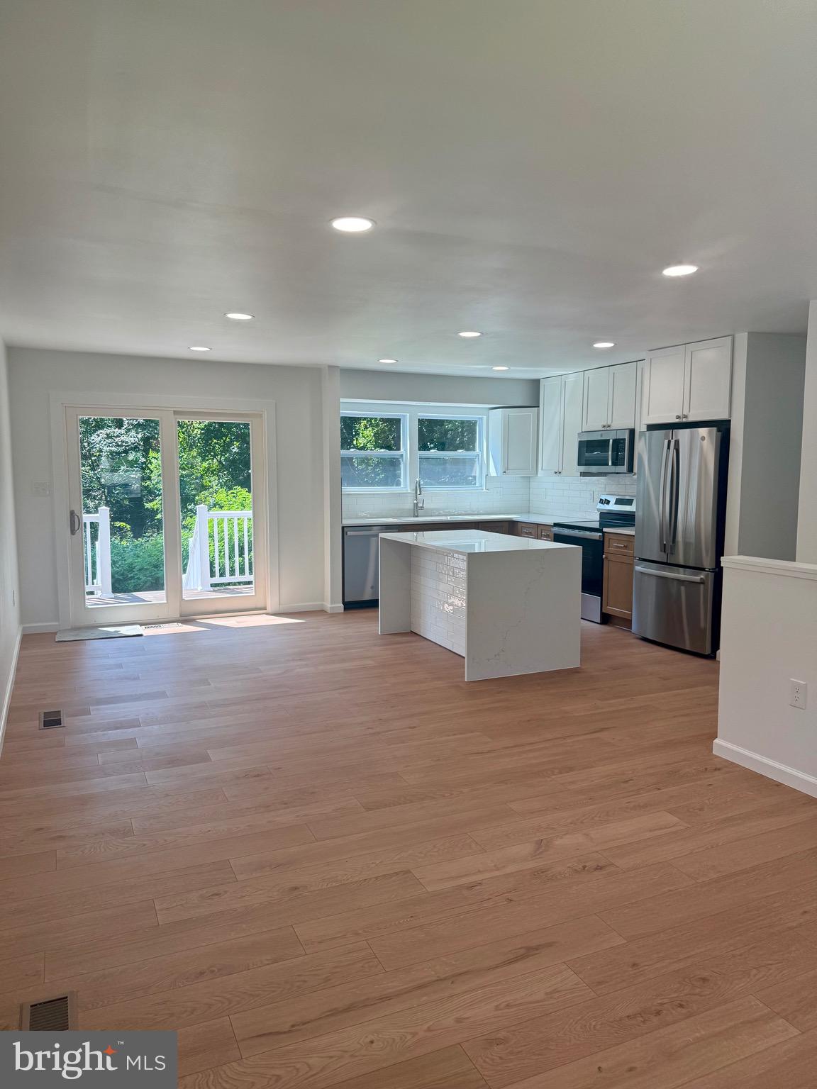 3600 4th Street North Beach, MD 20714 - Photo 3 of 32 a large kitchen with a large window and stainless steel appliances