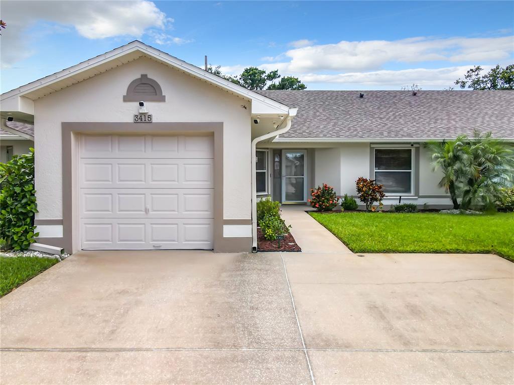 front view of a house with a yard and an trees
