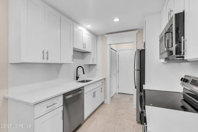 a kitchen with stainless steel appliances a refrigerator sink and cabinets