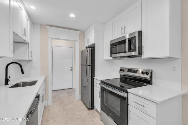 a kitchen with stainless steel appliances a stove microwave and sink