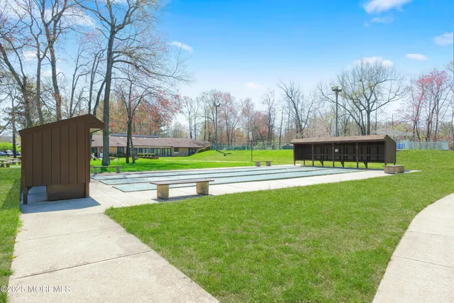a green field with lots of trees in the background