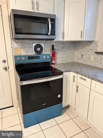 a kitchen with stainless steel appliances a stove and a microwave