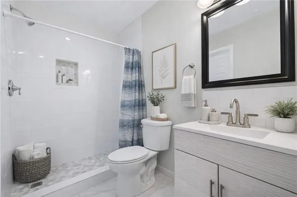 a bathroom with a toilet a sink a vanity and mirror