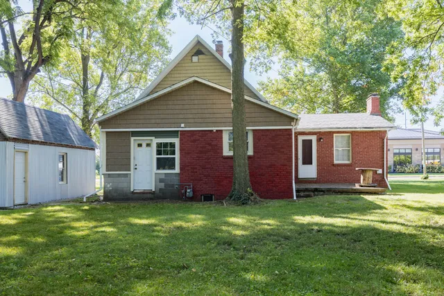 a view of a yard in front of a house with large tree