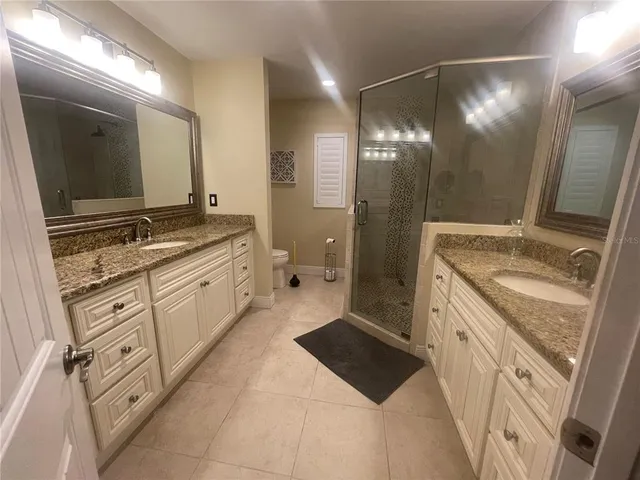 a spacious bathroom with a granite countertop sink mirror and a shower