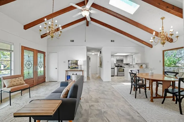 a living room with furniture a flat screen tv and a window