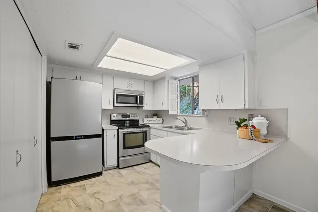 a kitchen with stainless steel appliances granite countertop a refrigerator sink and stove