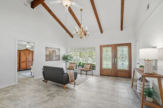 a living room with furniture a flat screen tv and next to a window