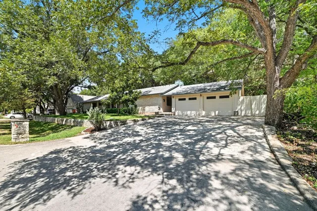 a backyard of a house with wooden floor and large trees