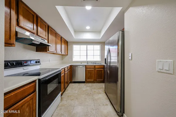 a kitchen with stainless steel appliances granite countertop a sink a stove and cabinets