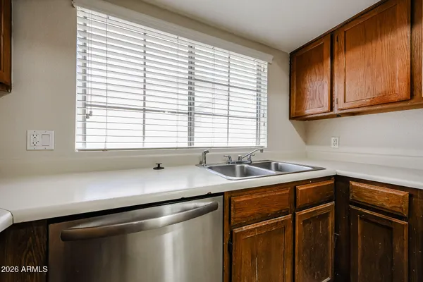 a kitchen with stainless steel appliances granite countertop a refrigerator a stove and a sink with wooden floor