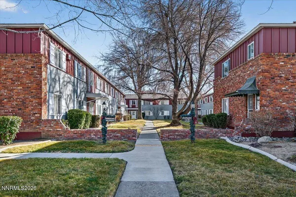 a view of a brick house with a yard
