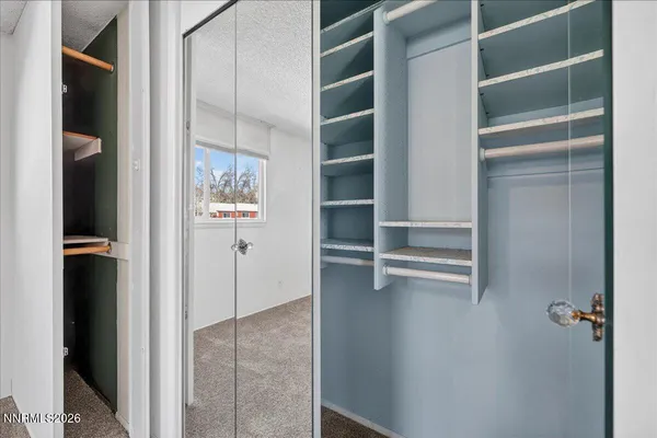 a view of walk in closet with empty racks