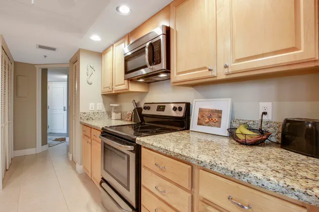 a kitchen with granite countertop stainless steel appliances a stove a microwave a sink and cabinets