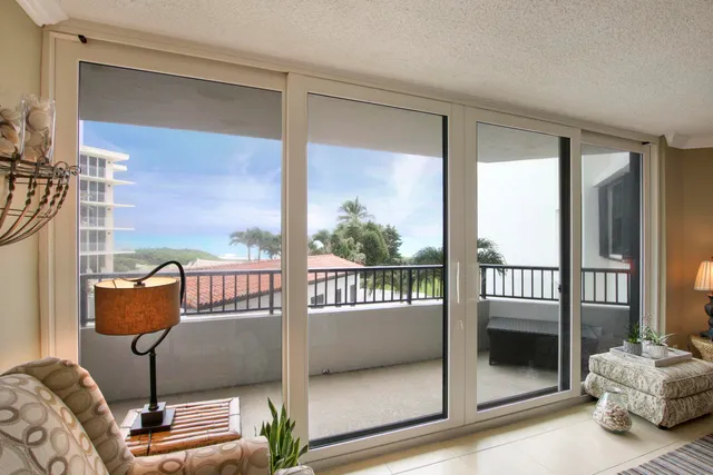 a balcony with view of couch and a potted plant on it