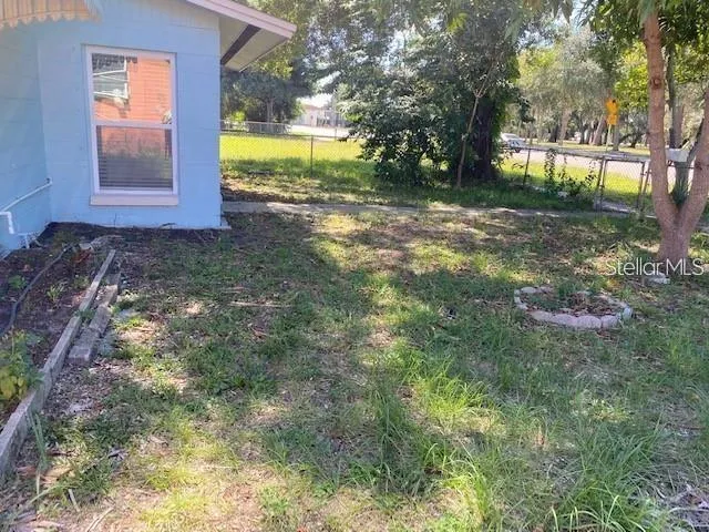 a view of a yard with yellow house