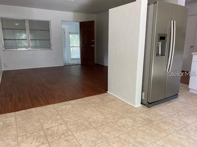 a view of a kitchen with wooden floor and a refrigerator