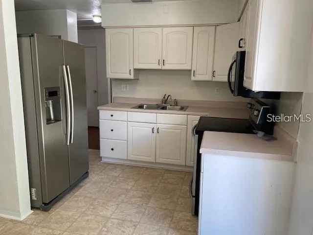 a kitchen with stainless steel appliances granite countertop a refrigerator sink and stove