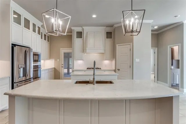 a large kitchen with stainless steel appliances kitchen island granite countertop a table and chairs in it