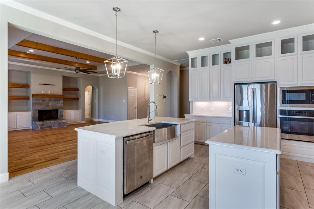 14717 Lost Wagon Street Justin, TX 76247 - Photo 13 of 37 a kitchen with stainless steel appliances granite countertop a sink and a refrigerator