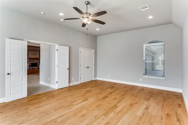 a view of an empty room with a window and wooden floor