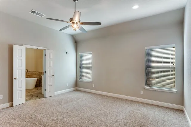 a view of a room with a ceiling fan and window