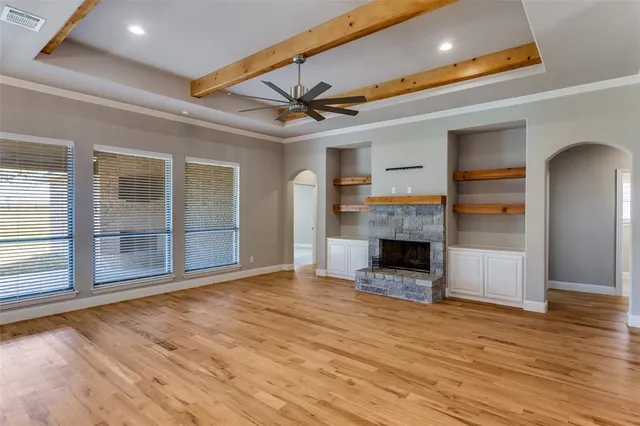 a view of an empty room with a fireplace and window