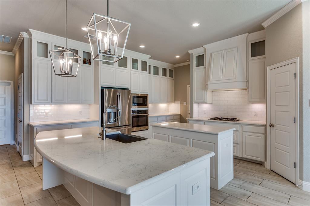 14717 Lost Wagon Street Justin, TX 76247 - Photo 10 of 37 a kitchen with stainless steel appliances granite countertop a sink refrigerator and stove
