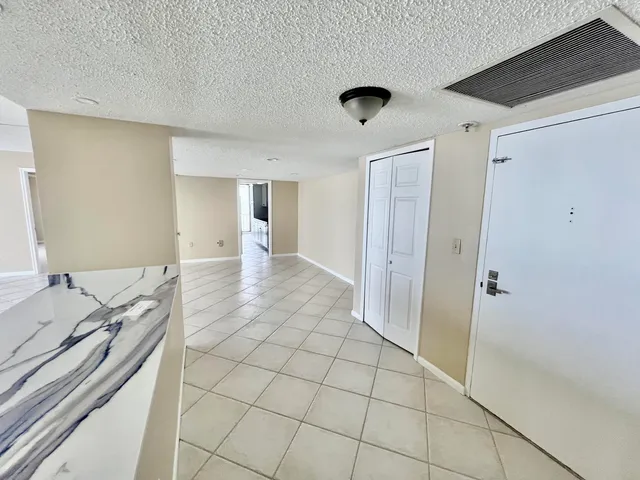 a view of an empty room with window and cabinet