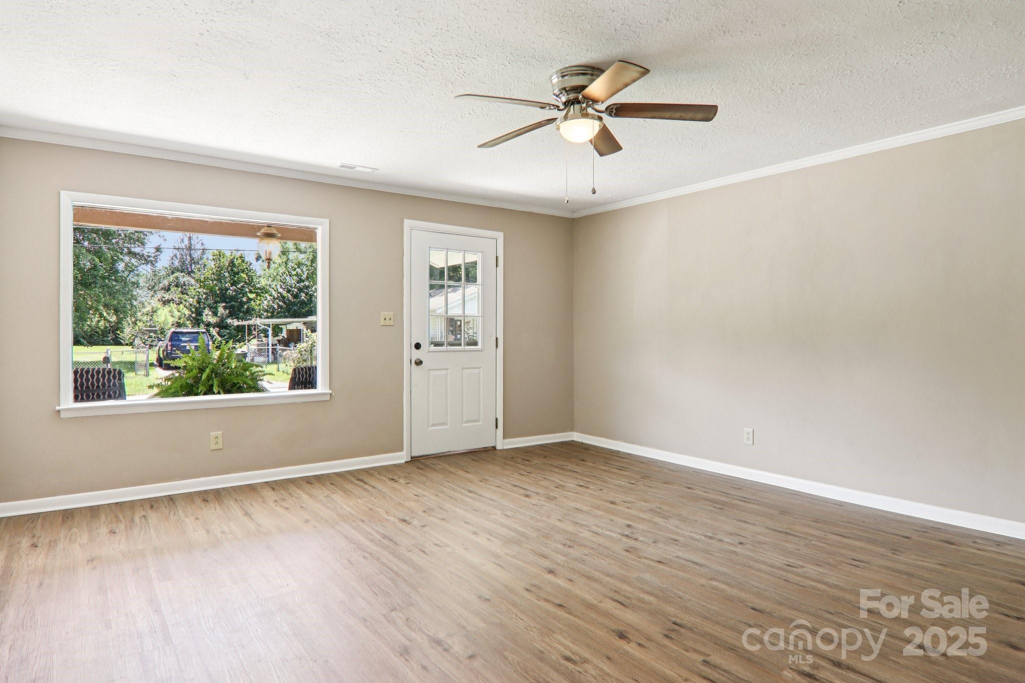 55 Polk Street Waynesville, NC 28786 - Photo 12 of 44 an empty room with wooden floor fan and windows