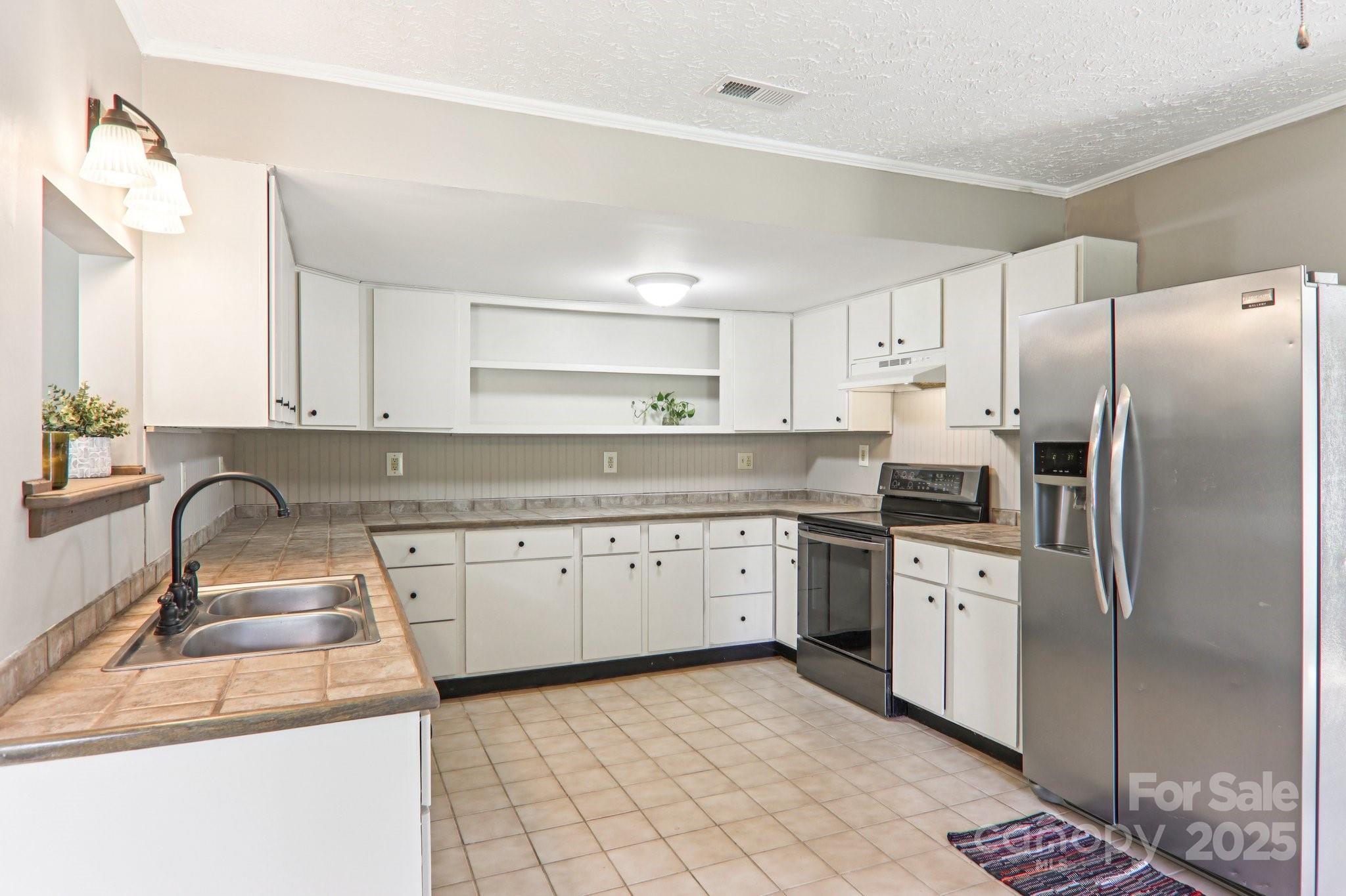 55 Polk Street Waynesville, NC 28786 - Photo 16 of 44 a kitchen with stainless steel appliances granite countertop a sink stove and refrigerator
